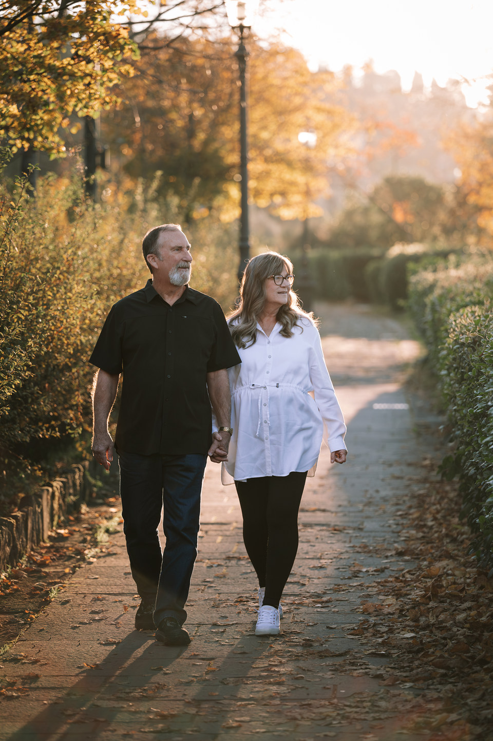 Couple walking together on a garden path above Florence at golden hour