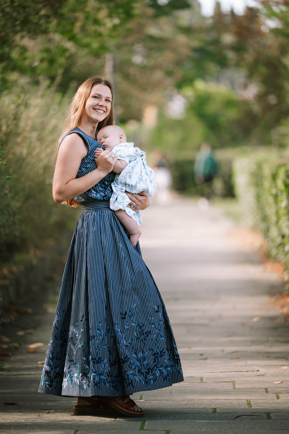 Mother holding her baby on a garden path in Florence